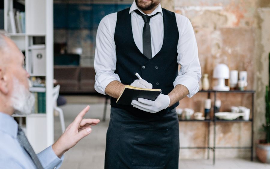 Un mozo tomando el pedido de un cliente en un restaurante